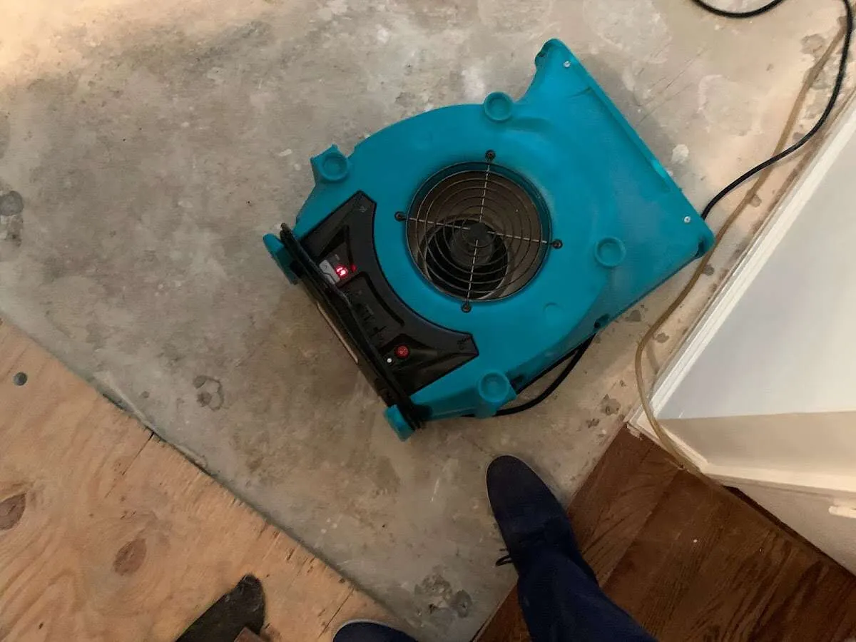 Air mover drying subfloor during Commercial Water Damage Restoration in Overland Park